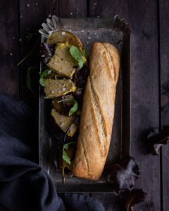 Bocadillo de Foie Gras de Pato y brotes verdes sobre bandeja metalica y fondo oscuro