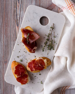 Tabla de marmol blanco con montaditos de jamón ibérico y lomo iberico